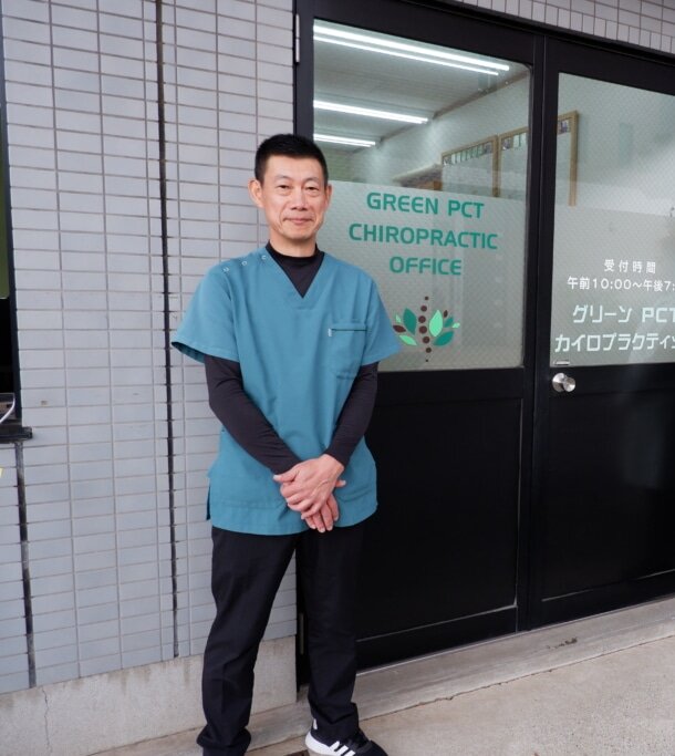 グリーンPCTカイロプラクティックの入口に立つ山田院長